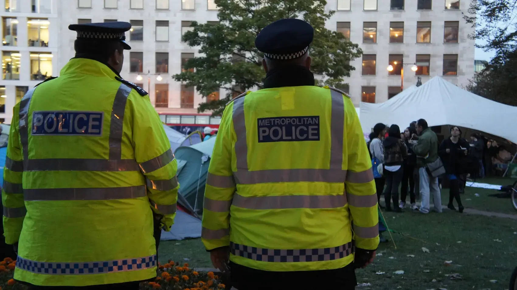 Metropolitan Police officers seen from behind in high-visibility jackets